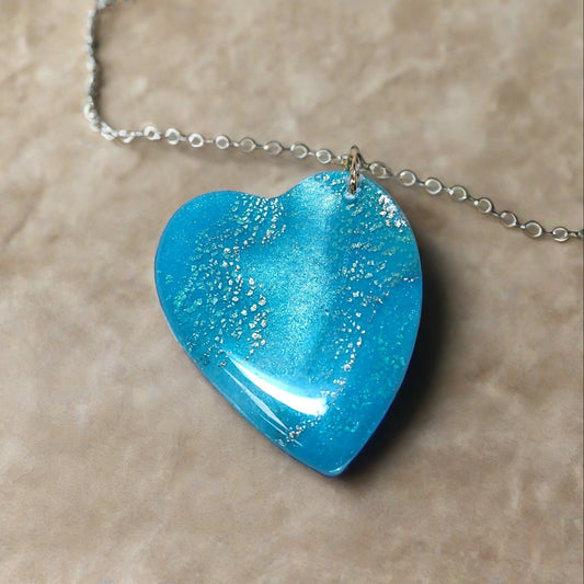 Heart shaped pendant.  Blue, pearl, teal, and gold flecks.
