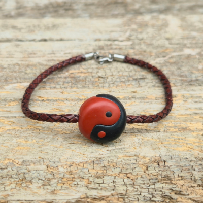 red and black yin yang symbol on braided leather bracelet